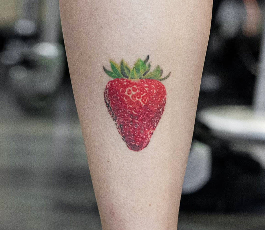 Hand poked strawberry tattoo done with red ink, located