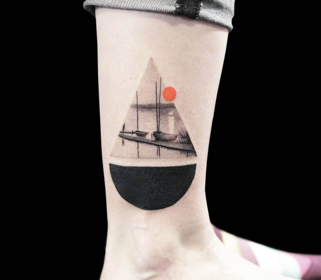 Minimalist sailboat tattoo on the tricep.