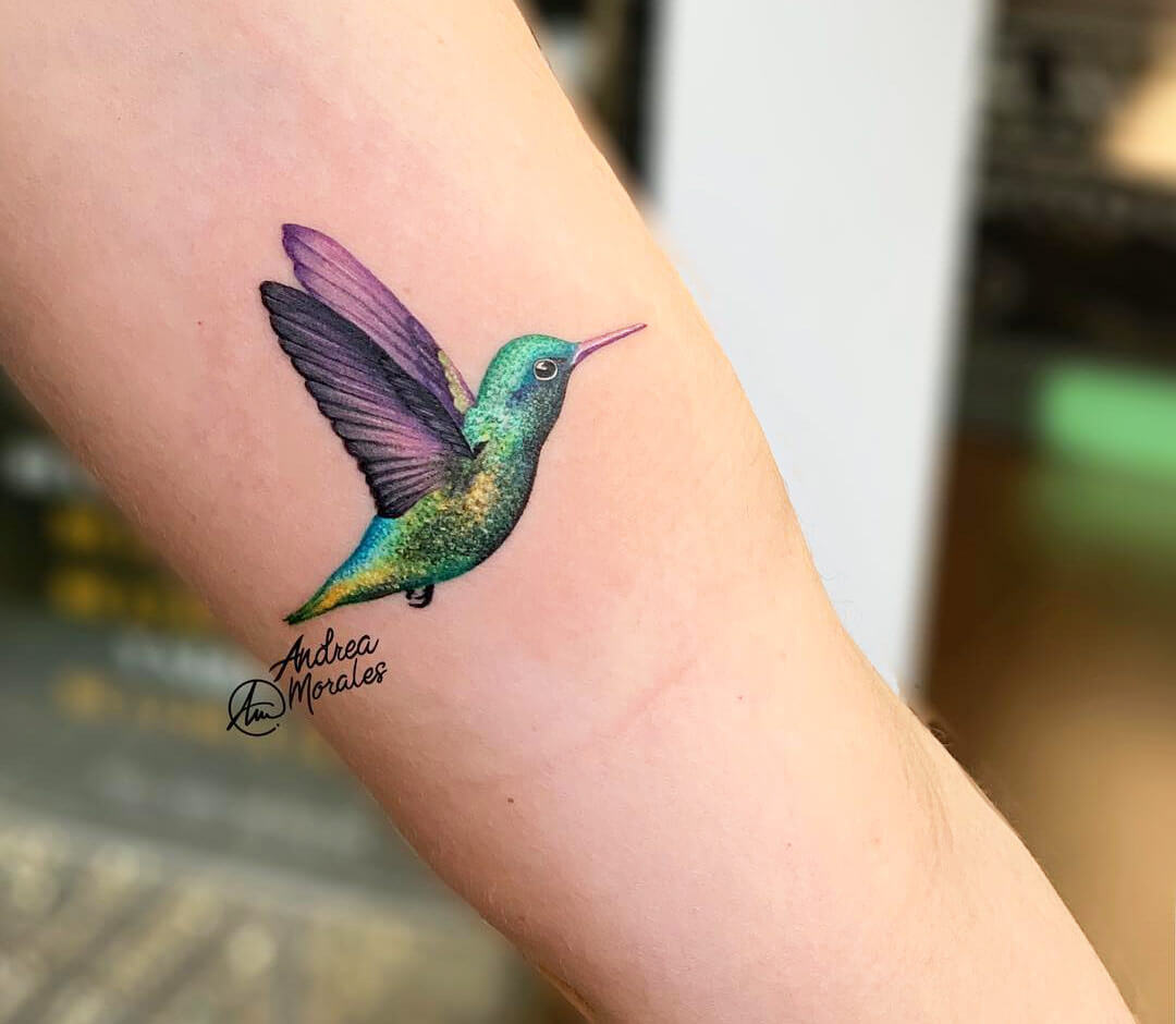 Colorful hummingbird tattoo located on the wrist.