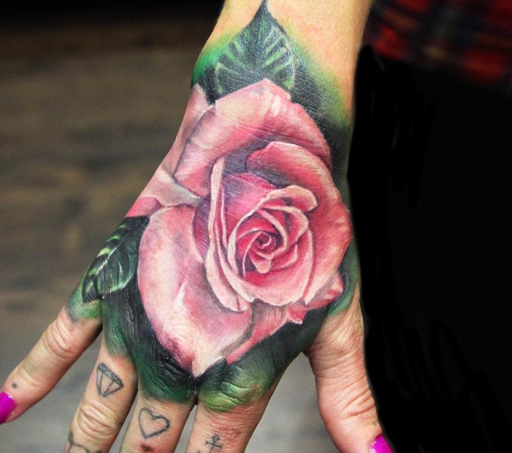 Matching traditional style rose tattoos on the hands
