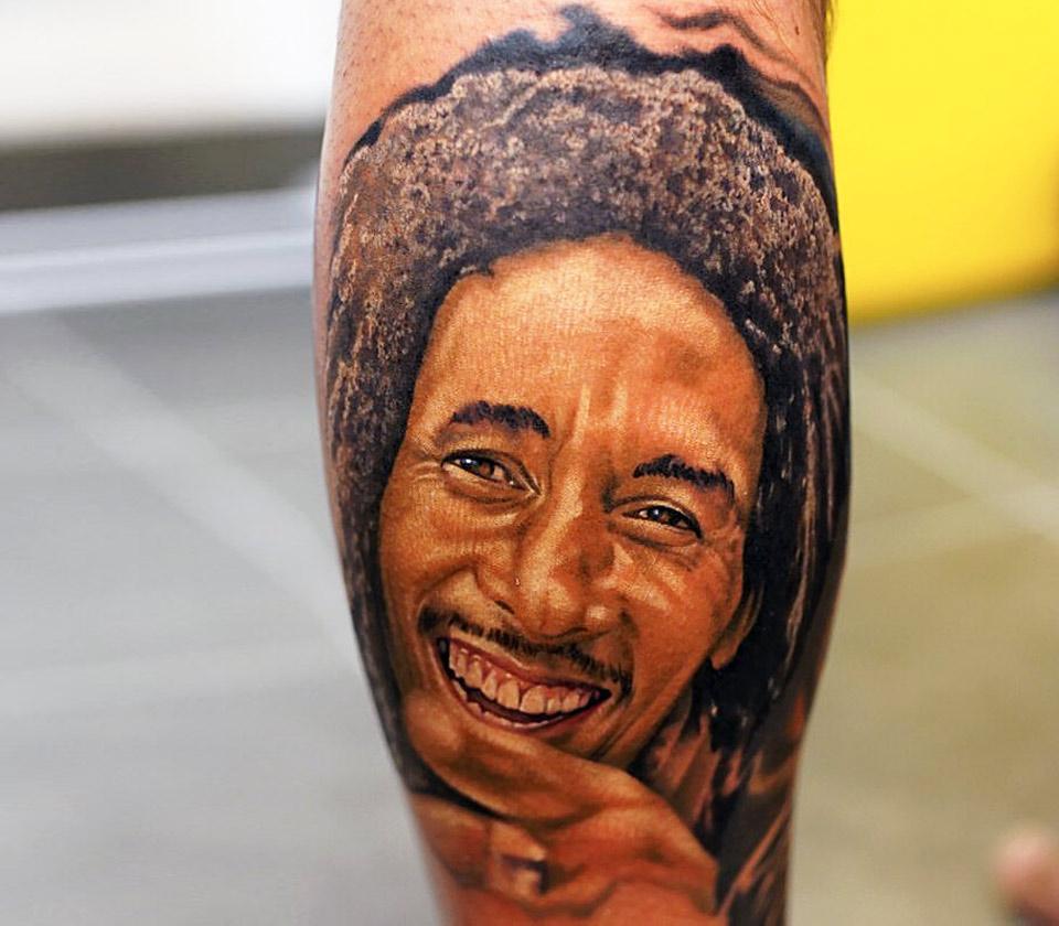 Tattoo artist Kiki applies a portrait of Bob Marley tattoo on Desai Smith,  of Bermuda, a student of J.F. Drake State Technical College of Alabama, as  he enjoys spring break in the