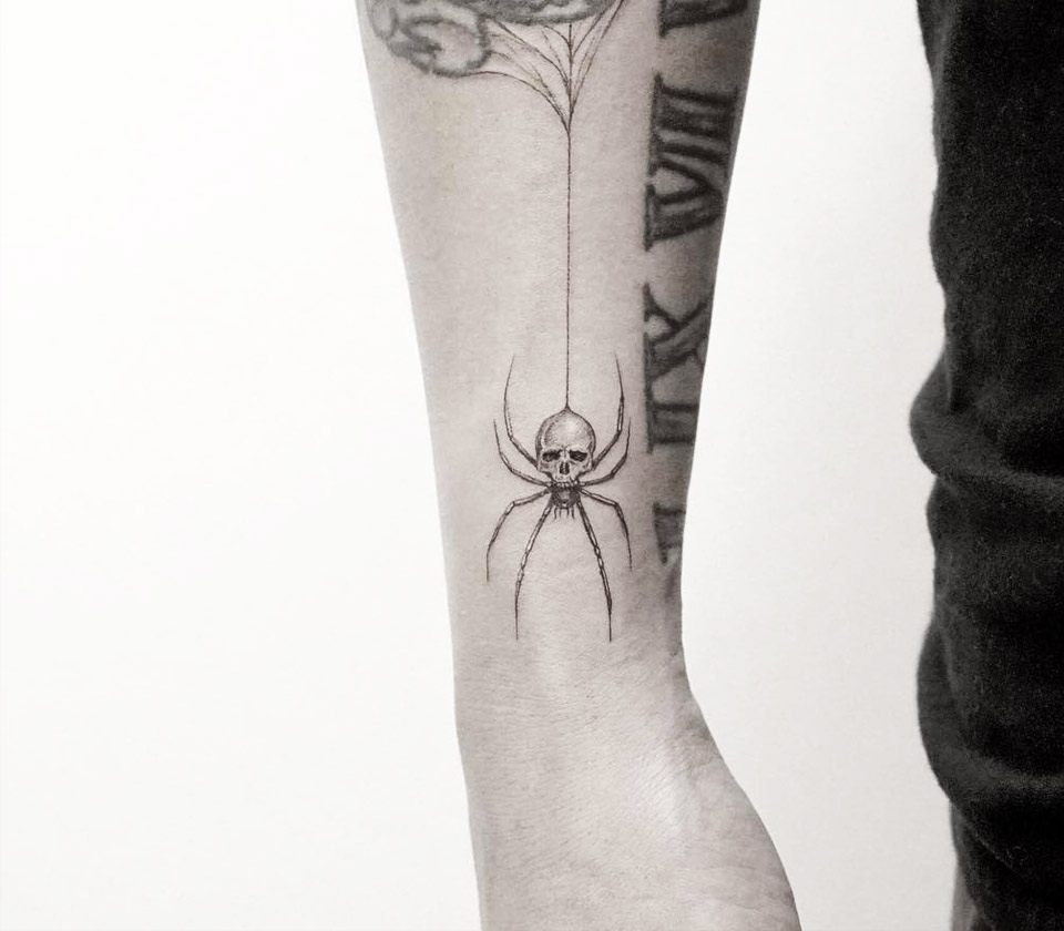 Spider skull tattoo on the inner arm