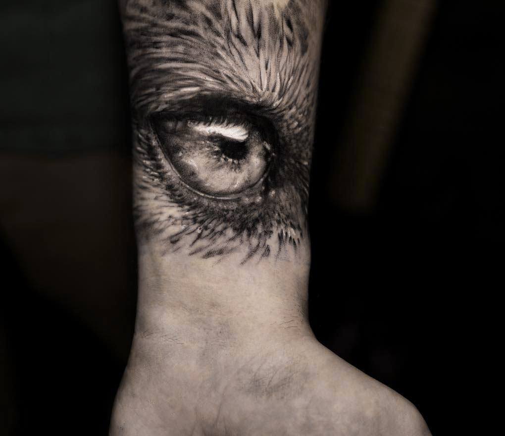 Realistic pink eye tattoo on the right inner forearm